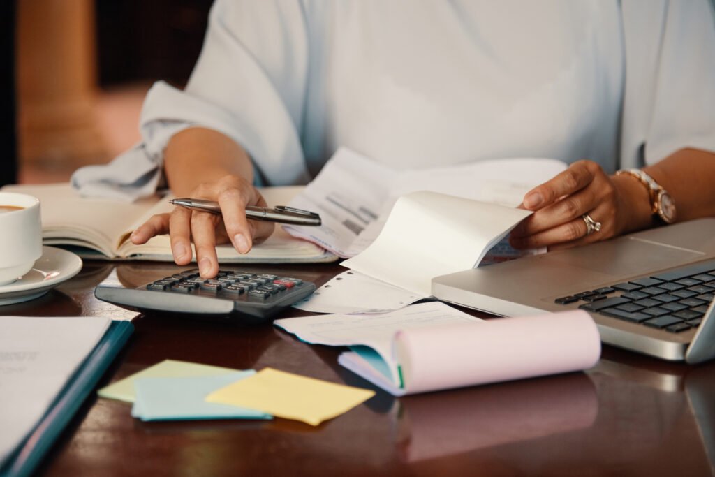Mãos de empreendedora organizando contas e documentos financeiros, representando a contabilidade estratégica para empresas do RJ.